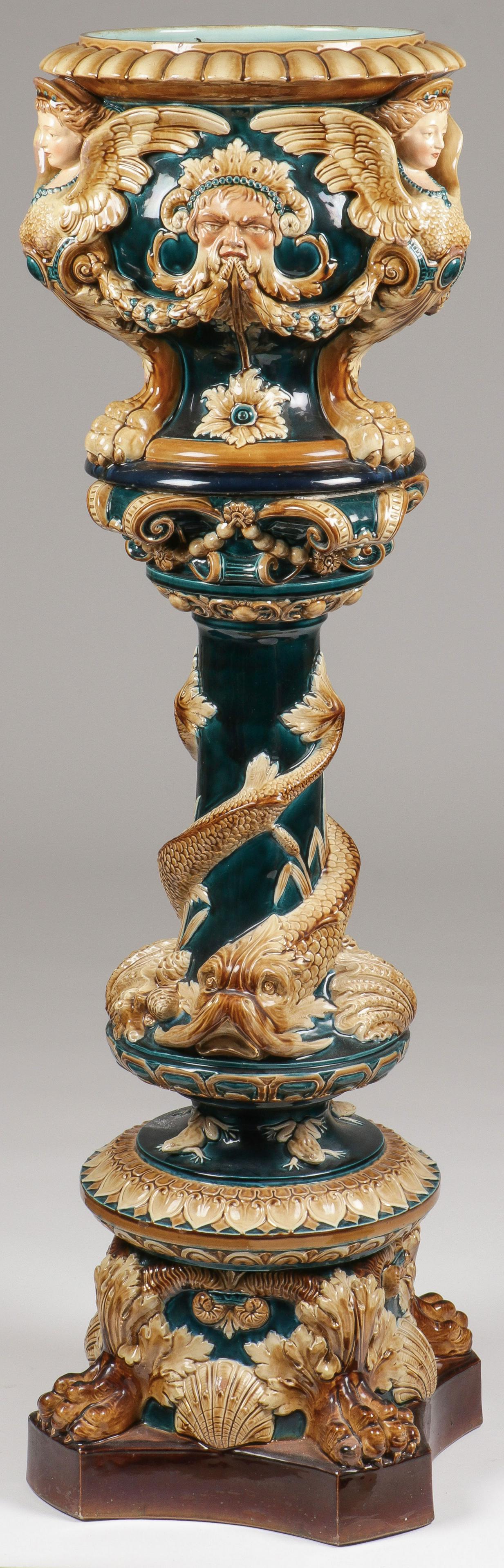 IMPRESSIVE MAJOLICA PEDESTAL & URN, 19TH C: IMPRESSIVE MAJOLICA PEDESTAL & URN, 19TH C. Comprising a large and impressive figural Majolica pedestal on shaped base with paw feet mounted corners and shell motifs beneath a circular leaf tipped pla