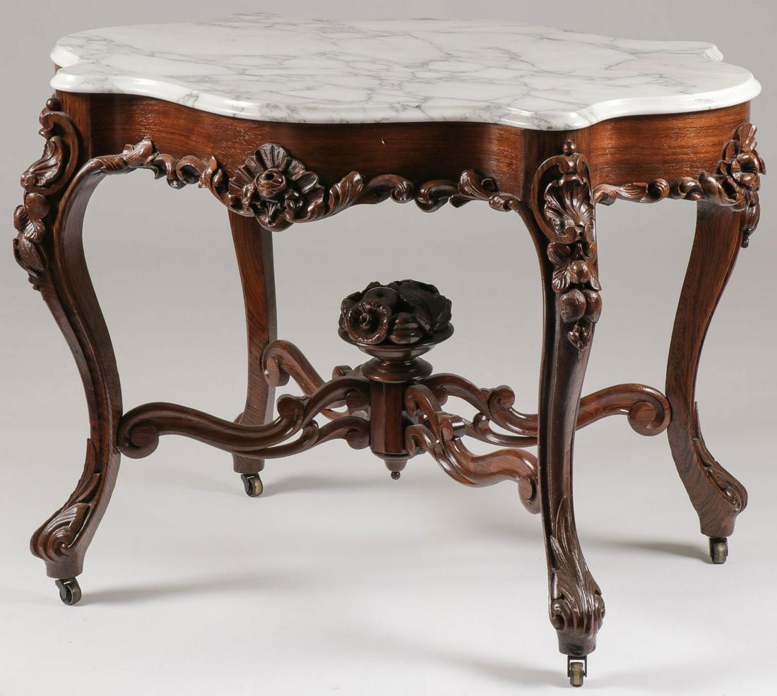 VICTORIAN MARBLE TOP PARLOR TABLE: VICTORIAN MARBLE TOP PARLOR TABLE. The beveled white marble top over conforming frieze with applied heavily carved foliage raised on four cabriole legs terminating in acanthus-carved scrolled feet on 