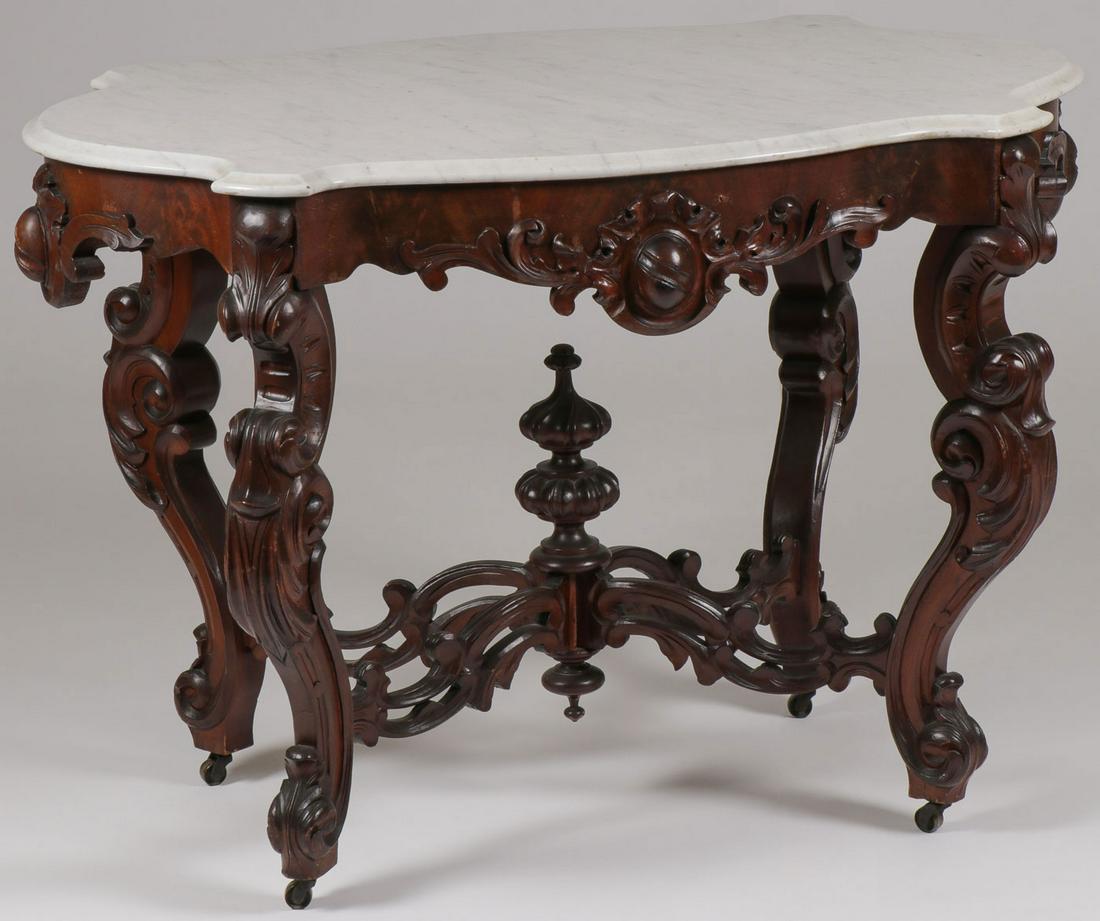 ROCOCO REVIVAL ROSEWOOD CENTER TABLE, 19TH C: ROCOCO REVIVAL ROSEWOOD CENTER TABLE, 19TH C. Comprising an impressive American Rococo revival Rosewood center table, the serpentine marble top over a conforming frieze with scroll and leaf carving ra