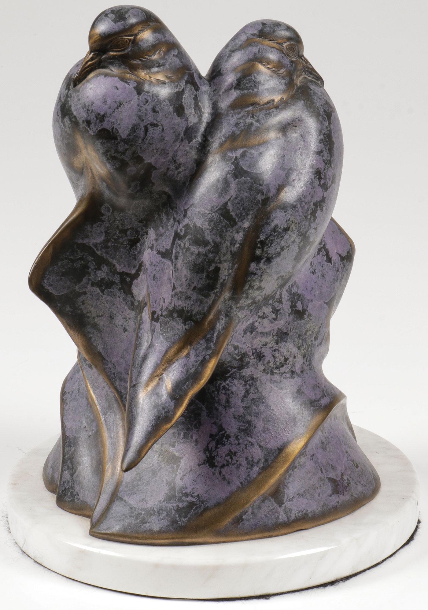 A BARBARA NELSON SIGNED LOVEBIRD BRONZE: A BARBARA NELSON SIGNED LOVEBIRD BRONZE. Comprising an attractive bronze figural grouping of two turtle doves with brown and lilac colored patina resting on a white polished marble base, artist signed