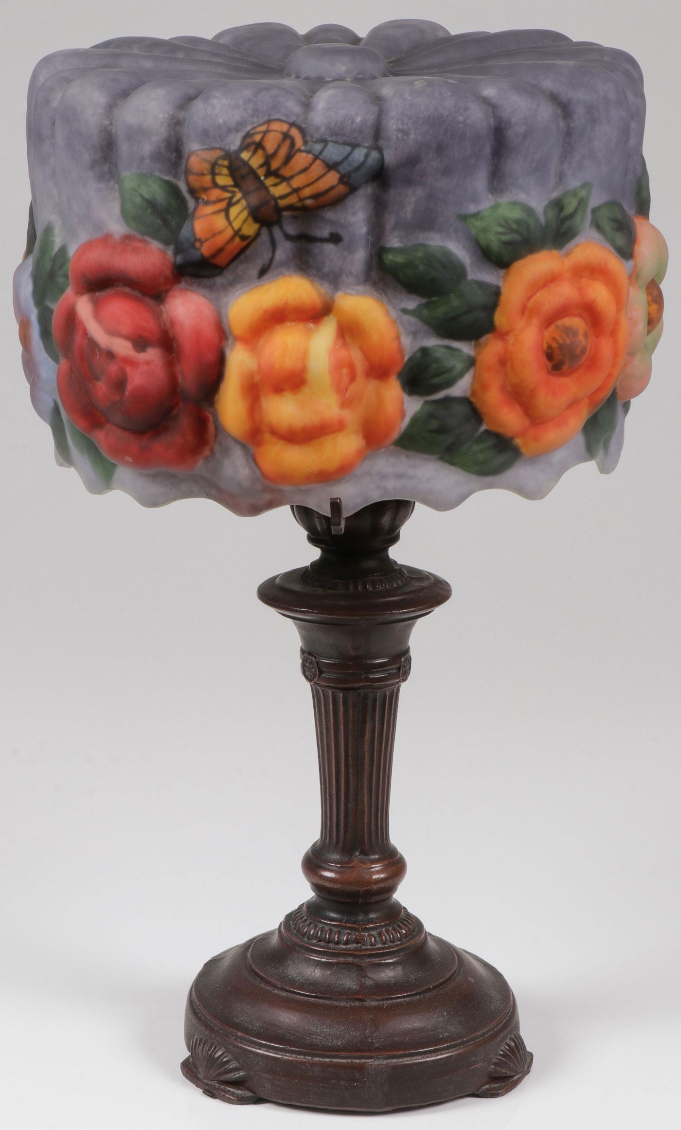 A REVERSE PAINTED PUFFY TABLE LAMP: A REVERSE PAINTED PUFFY TABLE LAMP. The reverse painted ribbed shade with blown out flowers and butterflies in the style of Pairpoint set on a bronzed metal baluster form base. Contemporary. Height 20