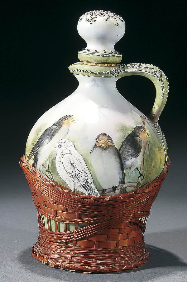 A VERY FINE NIPPON, MORIAGE & WICKER WINE JUG ear: A VERY FINE NIPPON, MORIAGE & WICKER WINE JUG early 20th century. Hand painted design of three birds on a limb further decorated with a raised moriage bird overlaid with a woven wicker base. Unmarked.