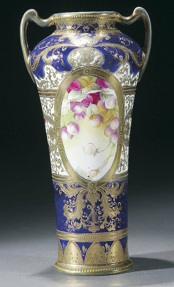 A FINE NIPPON COBALT PORCELAIN HANDLED VASE early: A FINE NIPPON COBALT PORCELAIN HANDLED VASE early 20th century, with hand painted florals within gilt scrolls on a cobalt ground. Green "M in wreath" mark. Height 12.25 inches (31 cm). Estimate $700-$