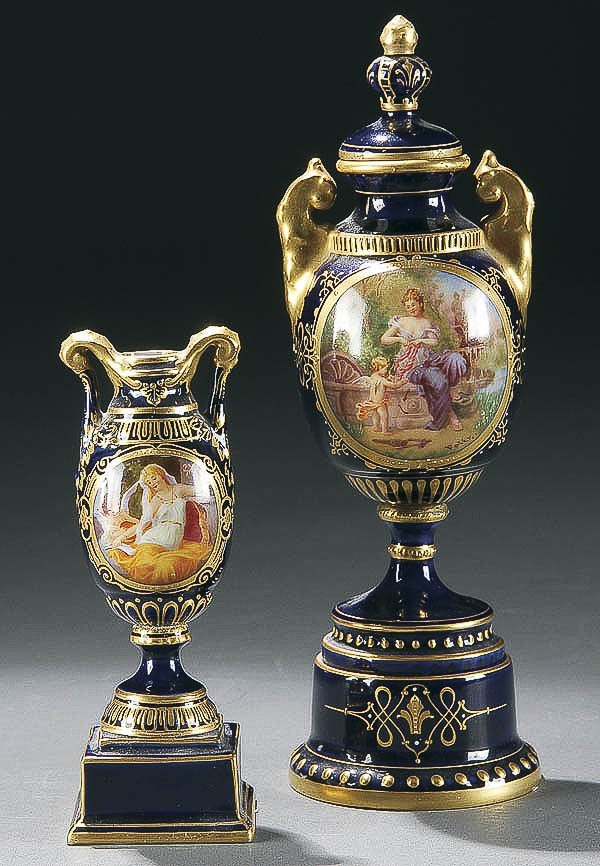 PAIR ROYAL VIENNA PORTRAIT CABINET URNS: A PAIR OF ROYAL VIENNA HAND PAINTED PORTRAIT CABINET URNS circa 1900 each with hand painted romantic scenes on cobalt blue with bolted pedestals, the largest artist signed "Felix". Blue underglaze shi