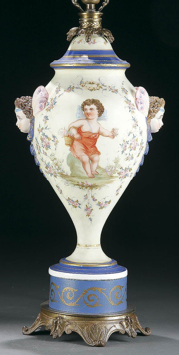 A GOOD FRENCH SEVRES STYLE PORCELAIN URN/LAMP, 19: A GOOD FRENCH SEVRES STYLE PORCELAIN URN/LAMP, 19th century, cream color urn form with cherub pictorial framed with scrolling roses adorned with two side cherub masks, set on later metal fitting with 