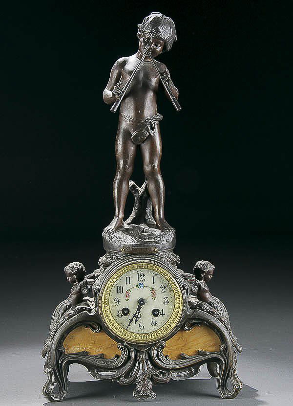 AFTER AUGUSTE MOREAU BRONZE CLOCK: AFTER AUGUSTE MOREAU 'BOY WITH FLUTES' FIGURAL BRONZE CLOCK titled 'Fascinateur'. Raised on a scrolled cherub handled pedestal with circular clock. Height 19 inches. Estimate $300-$500