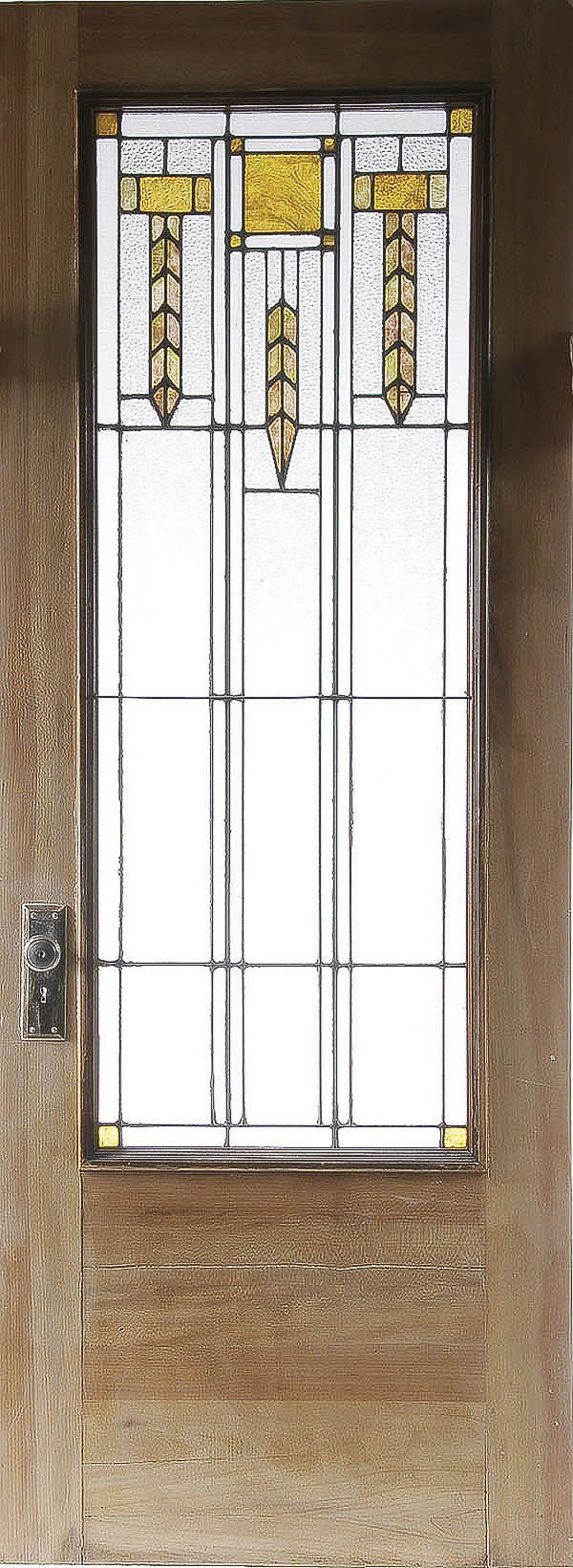 A PRAIRIE SCHOOL LEADED GLASS DOOR, attributed to: A PRAIRIE SCHOOL LEADED GLASS DOOR, attributed to Louis Sullivan, circa 1914. The wood framed door set with leaded amber and clear textured glass. The window, 55 inches x 21 inches and the door 80 inc