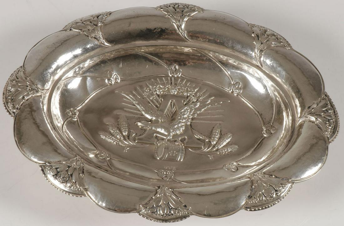 A VERY RARE ANHEUSER-BUSCH SILVER TRAY, GERMANY C: A VERY RARE ANHEUSER-BUSCH SILVER TRAY, GERMANY CIRCA 1900. Comprising a deep silver oval tray with scalloped rim repousséd with blossoming flower vines and the cavetto with high relief repousséd An