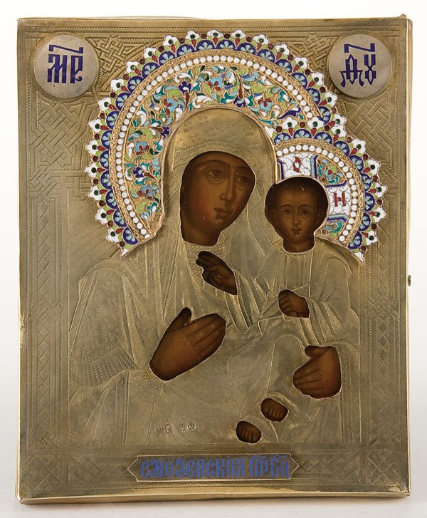 Russian Icon: Smolensk Mother of God: A RUSSIAN ICON: The Smolensk Mother of God. With gilt metal engraved riza, enameled haloes and title plaques. Contained in a glazed kiot. Comprised of both 19th century and 20th century elements. Icon