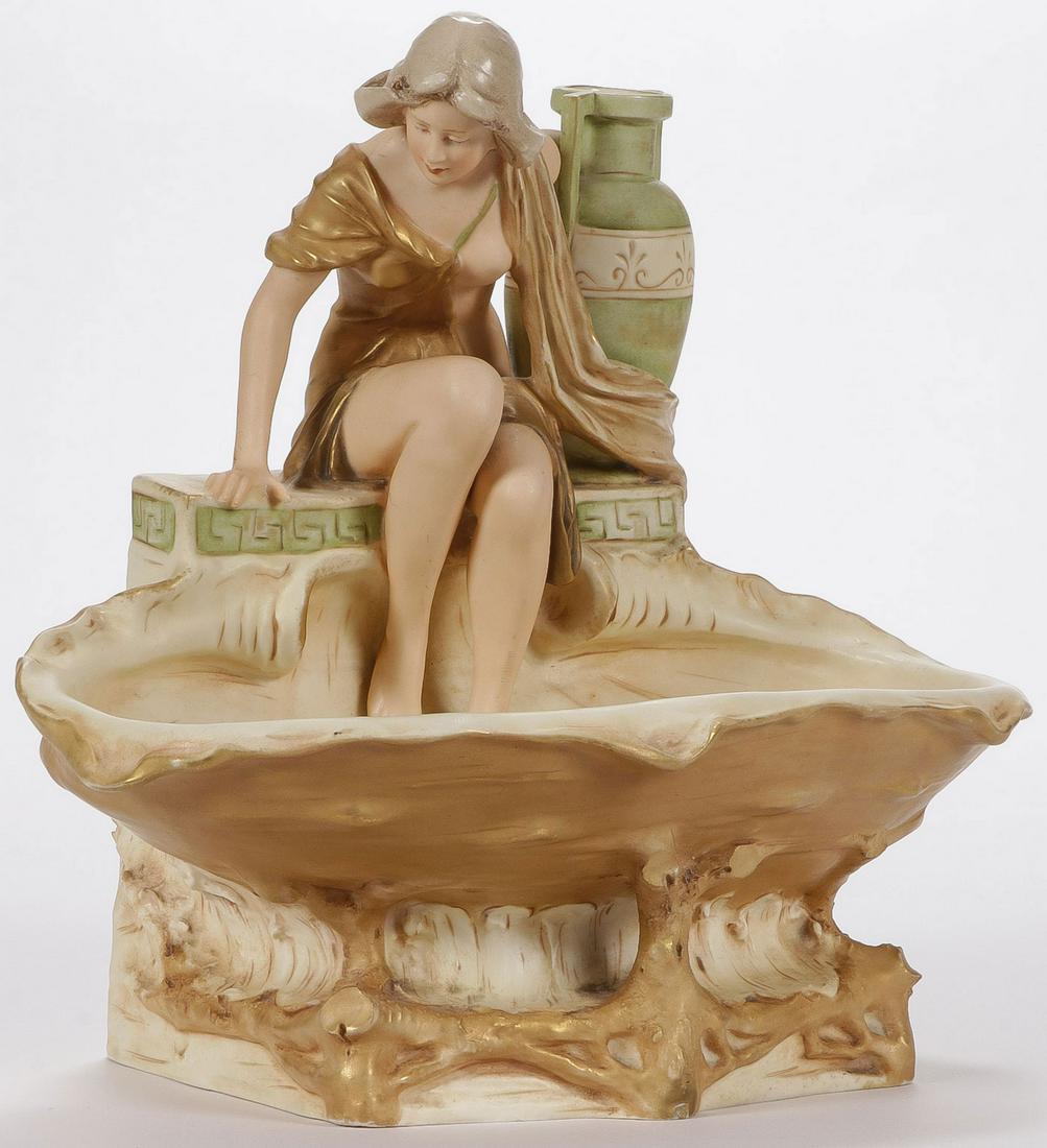 ROYAL DUX FIGURAL ART NOUVEAU BOWL: ROYAL DUX FIGURAL ART NOUVEAU BOWL. Finely modeled with woman resting on a clam shell reserve holding a Grecian urn. Underside of base with pink triangle Royal Dux seal. Verso inscribed with artist na