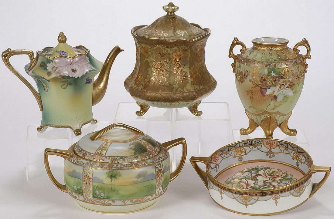 FIVE NIPPON PORCELAIN PIECES: FIVE NIPPON PORCELAIN PIECES. Each ornately decorated, some with jewels, and all with gilt highlights including a biscuit jar, teapot, covered bowl, and other as shown. Greatest height 9 inches. SHIPP