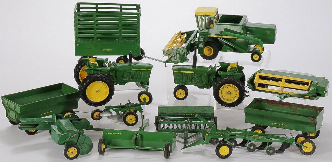 JOHN DEERE TOYS: JOHN DEERE TOYS. Comprising 12 John Deere agricultural toys, including tractors, combine, bailer, plow, wagons, and other pieces, various makers, ages, and conditions as shown.SHIPPING NOTICE:Jackso