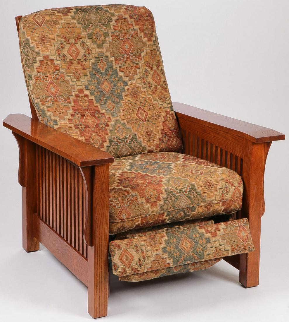 A MISSION OAKS STYLE RECLINER: A MISSION OAKS STYLE RECLINER. Comprising an Arts and Crafts style recliner upholstered in a multi colored fabric with a geometric pattern throughout flanked by slatted sides and wide arm rests. The c