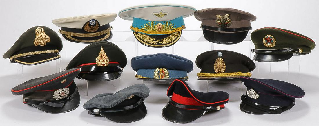 MIXED FOREIGN MILITARY CAPS: MIXED FOREIGN MILITARY CAPS. Comprising 12 individual peaked caps representing various countries and organizations including East German, Soviet Russia, Argentinian, Thai, and others as shown. SHIPPIN