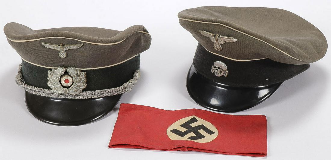 TWO GERMAN WWII STYLE CAPS: TWO GERMAN WWII STYLE CAPS. Including an army officer's peaked cap and an SS officer's peaked cap, missing chinstrap chord, and a vintage printed arm band. Both hats post war but very convincing. SHIP