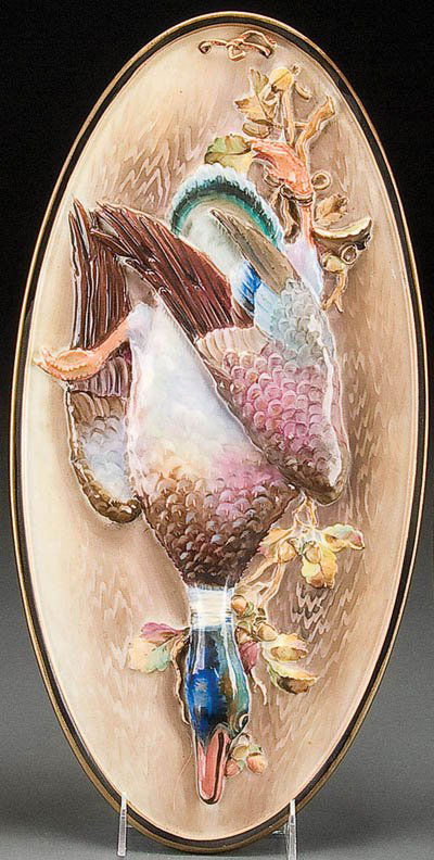 NIPPON PORCELAIN MALLARD GAME PLAQUE: A RARE HAND PAINTED NIPPON PORCELAIN 'MALLARD' GAME PLAQUE early 20th century, with sculpted and molded in relief design of a game mallard on oval panel. Pierced holes for suspension. Green M in wreat