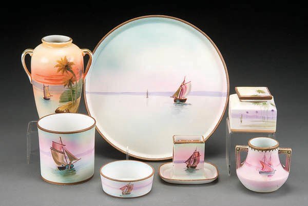 A HAND PAINTED NIPPON SAILBOAT SCENE DESK SET ear: A HAND PAINTED NIPPON SAILBOAT SCENE DESK SET early 20th century, consisting of 10-inch tray, matchholder, humidor (lid absent), 3.5-inch dish together with a similar scene 3-inch handled vase and 3-i