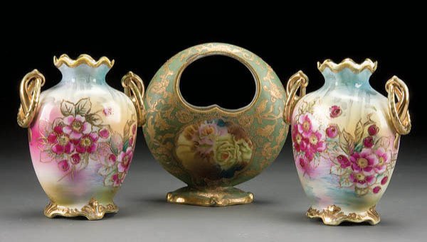 3 HAND PAINTED NIPPON PORCELAIN VASES early 20th: 3 HAND PAINTED NIPPON PORCELAIN VASES early 20th century, consisting of a basket vase and a pair of matching ring handled vases. Blue maple leaf marks. Height 7 & 8 inches. Estimate $100-$200 Referenc