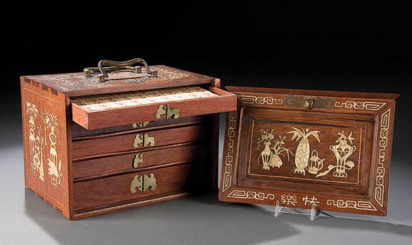 A CHINESE IVORY AND ROSEWOOD MAH-JONG SET contain: A CHINESE IVORY AND ROSEWOOD MAH-JONG SET contained in a five-drawer cabinet, height 5.75 inches. Estimate $50-$100