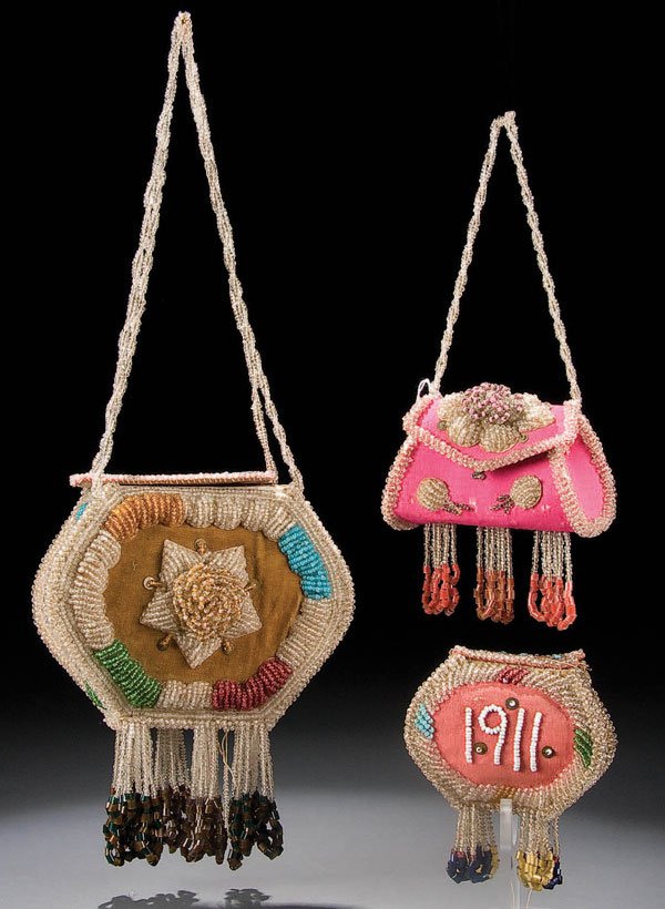 A GROUP OF IROQUOIS BEADED PURSES OR BAGS the lar: A GROUP OF IROQUOIS BEADED PURSES OR BAGS the largest dated 1908, the lid with the word 'BOX'. Overall length including handle and fringe 18 inches. The other with pink field with long handle and the 