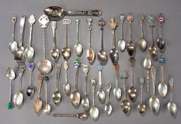 SEVENTY-FOUR SOUVENIR SPOONS mid 20th century, fr: SEVENTY-FOUR SOUVENIR SPOONS mid 20th century, from throughout the world, including 23 silver spoons (8.8 ounces), enameled bowls and figural handles. Estimate $50-$100