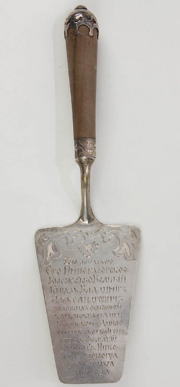 AN INTERESTING IMPERIAL RUSSIAN CEREMONIAL TROWEL: AN INTERESTING IMPERIAL RUSSIAN CEREMONIAL TROWEL the large blade set in a cylindrical wood handle with ornate mounts and engraved in Slavonic script "This trowel was used by His Imperial Highness the