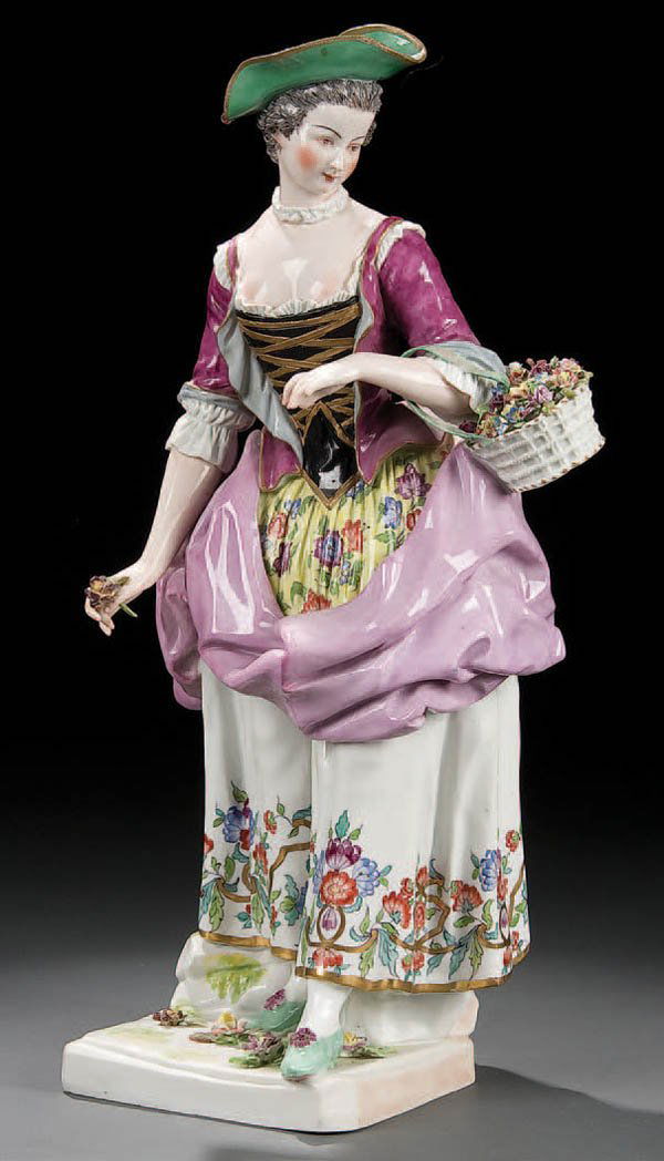 A FINE GERMAN PORCELAIN FIGURE circa 1900, of a w: A FINE GERMAN PORCELAIN FIGURE circa 1900, of a well dressed young woman with floral basket. Blue underglaze crossed mark probably for Samson. Height 16 inches. Estimate $400-$600 Euro 300-400