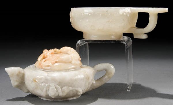 A CHINESE CARVED JADEITE WINE POT AND HANDLED CUP: A CHINESE CARVED JADEITE WINE POT AND HANDLED CUP 19th/early 20th century, the lidded wine pot in green and amber mixed tones carved with bats and a dragon in relief. The handled cup in pale green wit