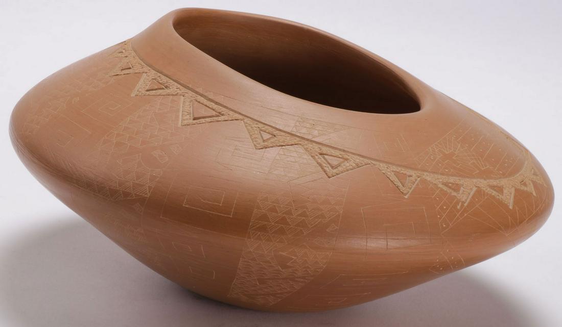 SANTA CLARA ETCHED REDWARE JAR: SANTA CLARA ETCHED REDWARE JAR. Of squashed bulbous form. The body overall incised and carved with geometric designs by noted Santa Clara artist Jody Folwell. Signed on underside of base. Height 4.5 i