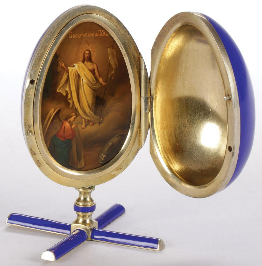 UNIQUE RUSSIAN SILVER & ENAMEL EGG, GRACHEV: UNIQUE RUSSIAN SILVER & ENAMEL EGG, GRACHEV. The blue enameled egg on conforming enameled spread foot base, opening to reveal a finely painted image of the resurrected Christ. The interior brightly gi