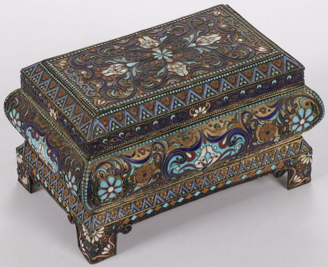 A RUSSIAN SILVER AND ENAMEL CASKET: A RUSSIAN SILVER AND ENAMEL CASKET. Resting on bracket feet, the Bombay form casket with hinged lid opening to reveal a brightly gilded interior. The exterior overall enameled with flower forms and re