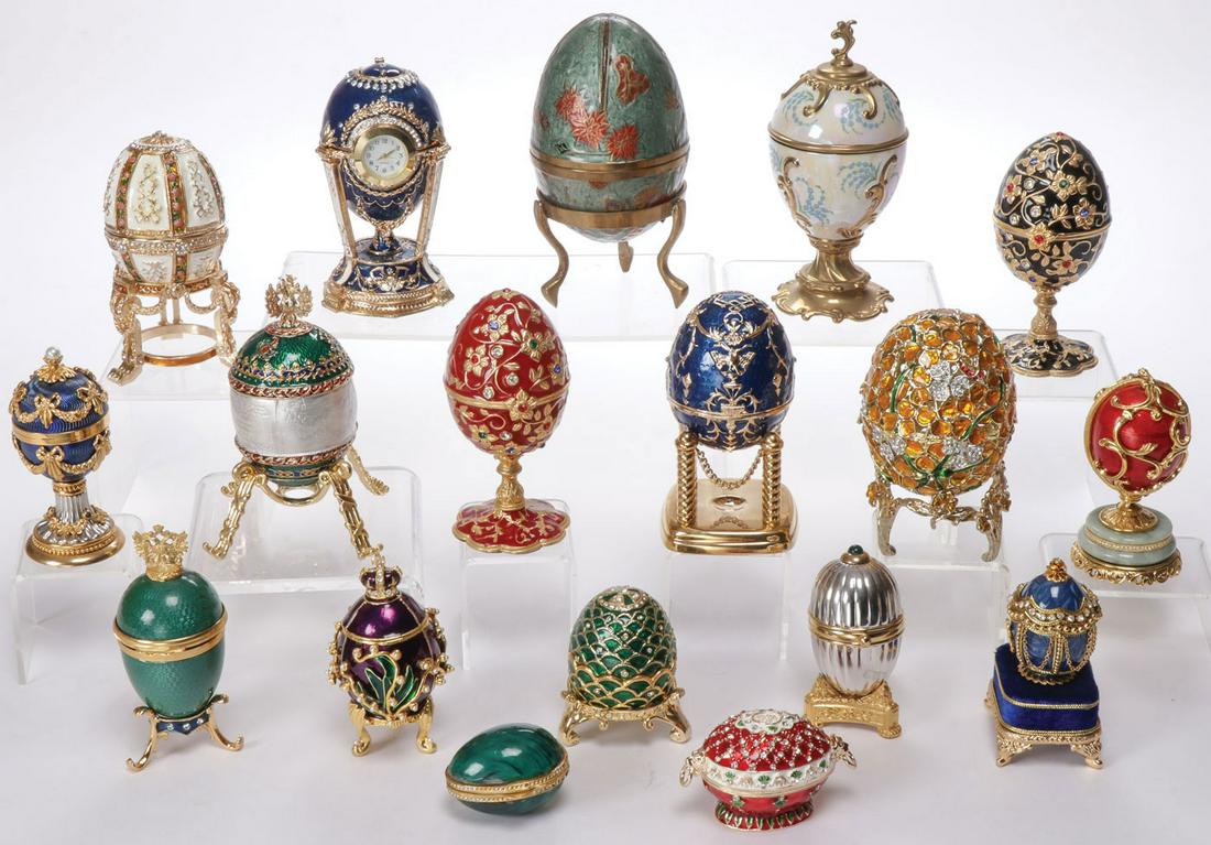 18 FABERGÉ STYLE EASTER EGGS: 18 FABERGÉ STYLE EASTER EGGS. Comprising 18 individual eggs, some modeled after famous Imperial Presentation Eggs, made from a variety of materials including gilt metal, enamel, paste stones, some op