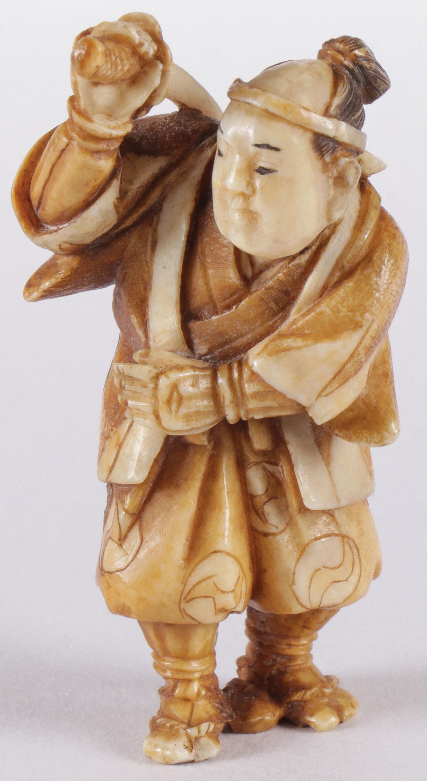JAPANESE CARVED SAMARAI NETSUKE, MEIJI: JAPANESE CARVED SAMARAI NETSUKE, MEIJI. Comprising a finely carved netsuke in the form of a sword wielding figure, carved in full round with great detail and signed on oval cartouche. Height 2 inches 