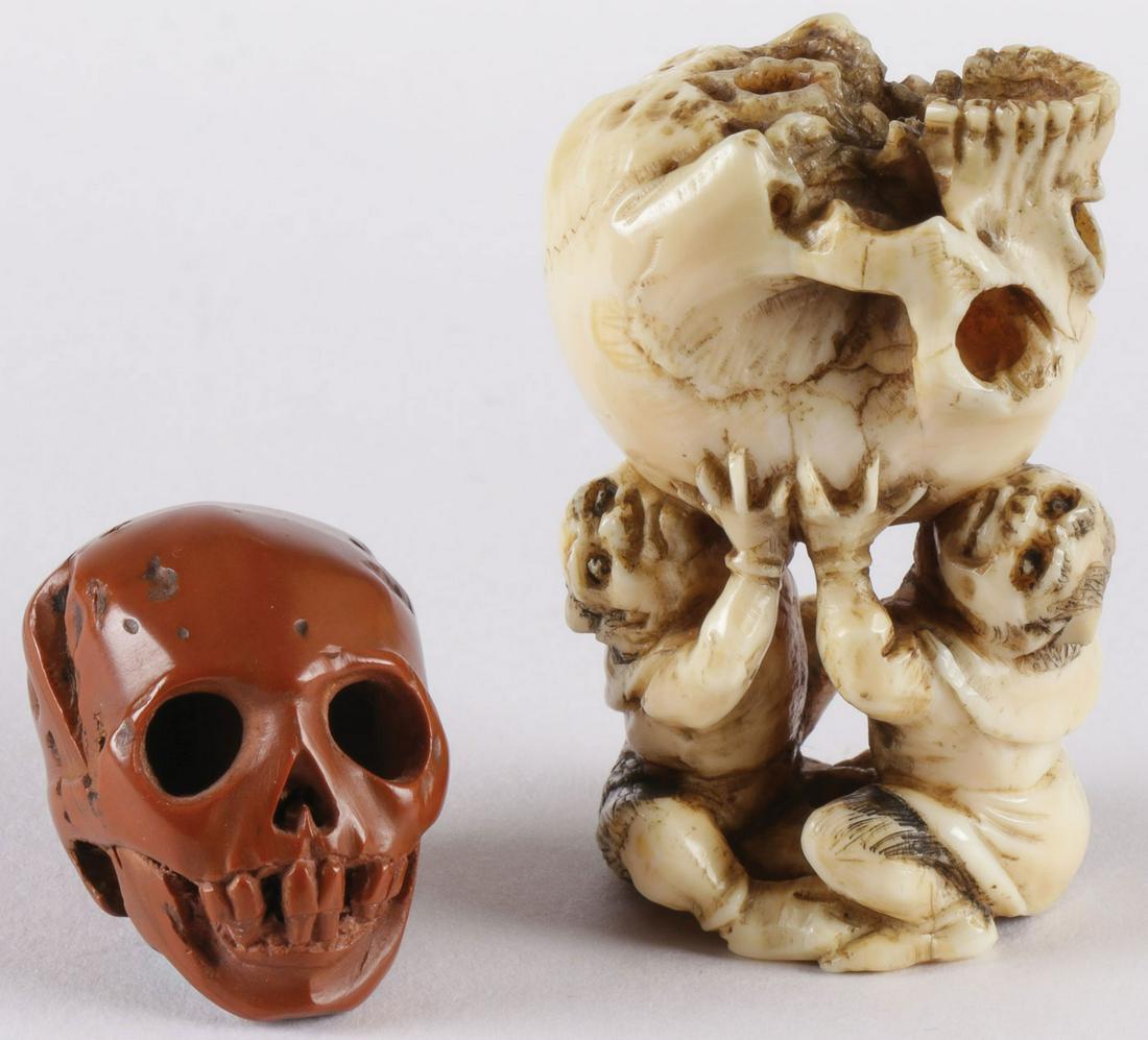 TWO CARVED JAPANESE SKULL NETSUKES: TWO CARVED JAPANESE SKULL NETSUKES. Comprising a carved wood or carved nut skull with good wear overall and a figure of two men holding a finely carved and anatomically correct human skull, signed on 