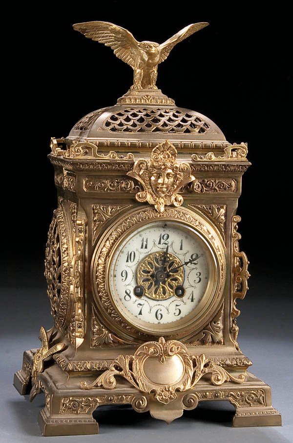 A VICTORIAN GILT BRONZE SHELF CLOCK 19th century,: A VICTORIAN GILT BRONZE SHELF CLOCK 19th century, with enameled chapter ring contained in an ornate decorated and reticulated case with eagle finial. Height 14 inches. Estimate $200-$300