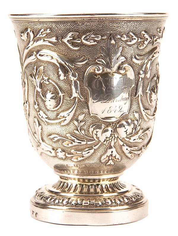 A RUSSIAN SILVER-GILT FOOTED BEAKER: A RUSSIAN SILVER-GILT FOOTED BEAKER, ST. PETERSBURG, 1842. The raised foot with foliage and holding a heavy flared cylindrical cup repoussed with scrolling foliates on a stippled ground, the front and