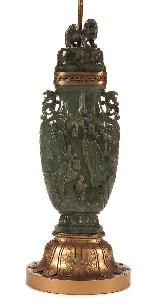 A LARGE CHINESE CARVED JADE HU FORM LIDDED URN: A LARGE CHINESE CARVED JADE HU FORM LIDDED URN, QING DYNASTY. Depicting Taoist figures in a mountainous landscape below a lid with Foo dog finial mounted later as a lamp raised on a gilt Lotus form ba