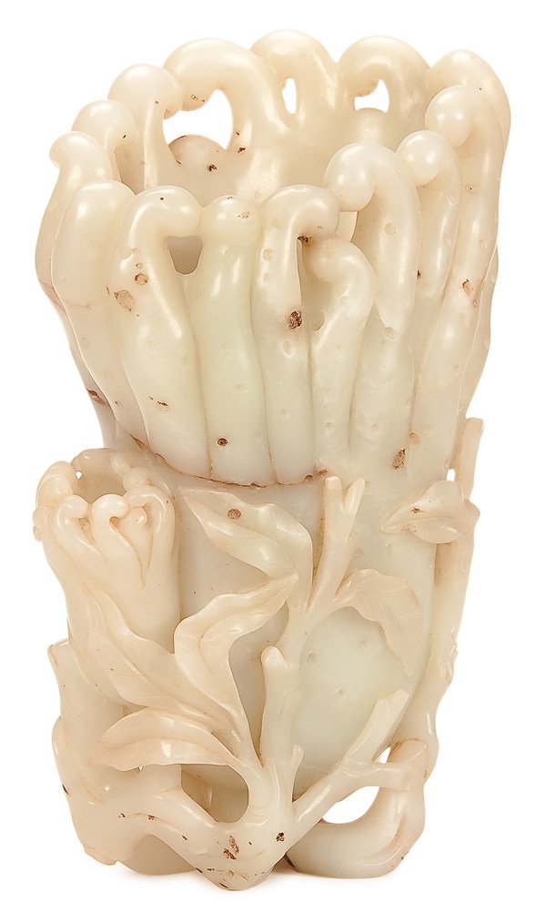 A CHINESE CARVED WHITE JADE BUDDHAS-HAND CITRON: A CHINESE CARVED WHITE JADE BUDDHAS-HAND CITRON, QING DYNASTY/EARLY REPUBLIC PERIOD. The hollowed citron with wavy fingers attached to a leafy base with smaller citron carved in pale green mutton fat