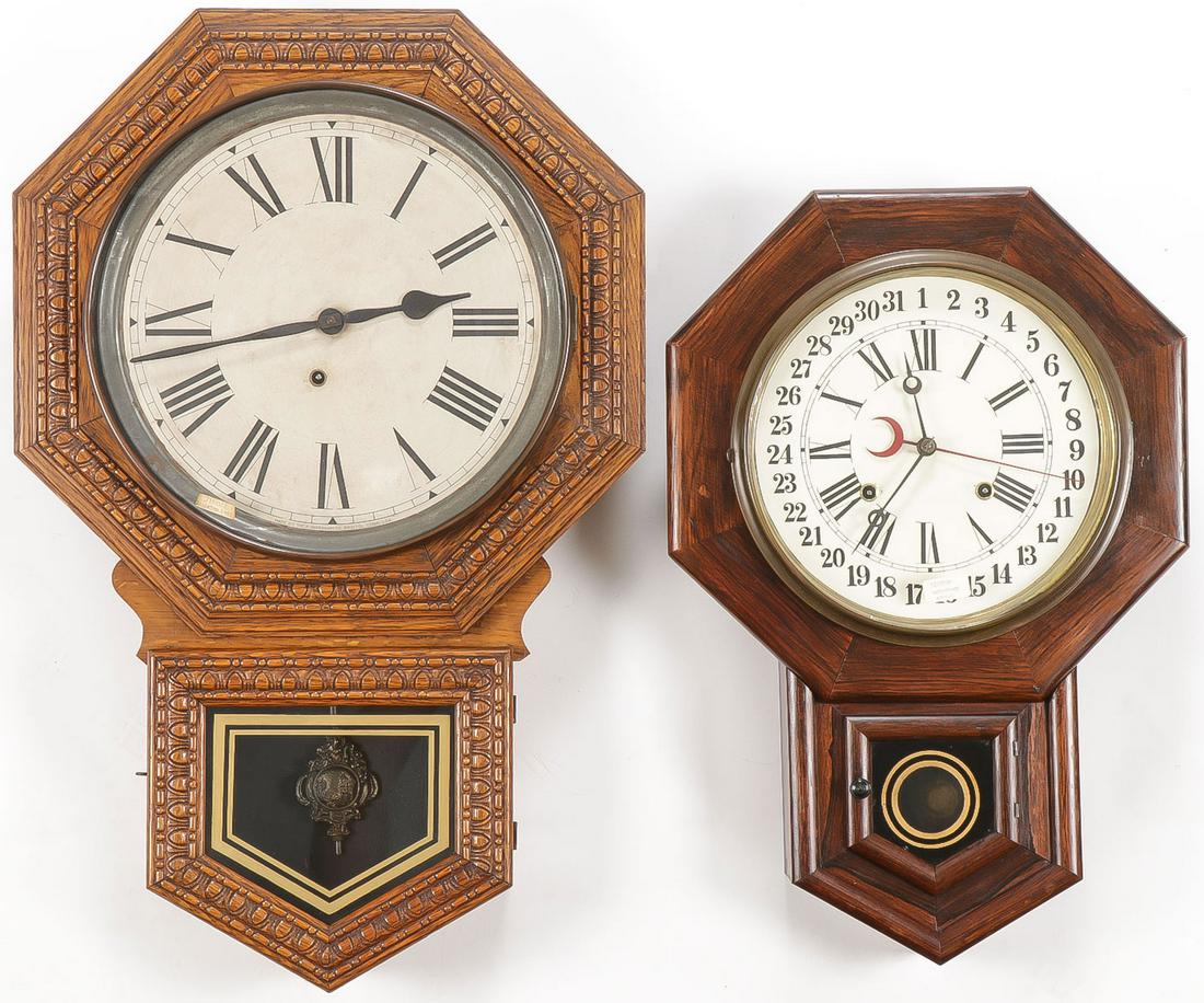 2 VINTAGE WALL CLOCKS: 2 VINTAGE WALL CLOCKS. Comprising two drop octagon wood case clocks both with glazed fronts opening to reveal metal faces with Roman numerals. One marked Ingrahm. Greatest height 27 inches SHIPPING NO