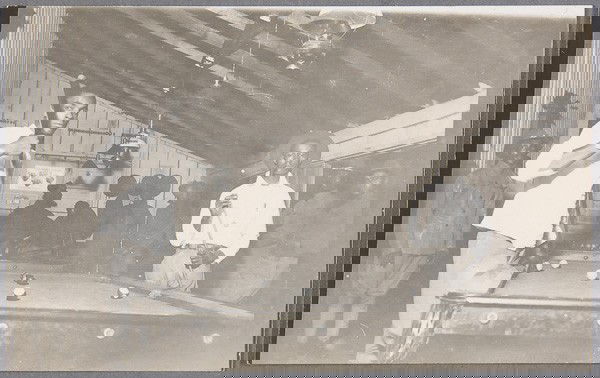 BLACK MEMORABILIA: MILITARY REAL PHOTO POSTCARD: A U.S. BLACK MILITARY BILLIARDS SCENE REAL PHOTO POSTCARD circa 1907. Depicting two black soldiers playing pool surrounded by black soldiers in uniform in background inside a wood barracks. The verso