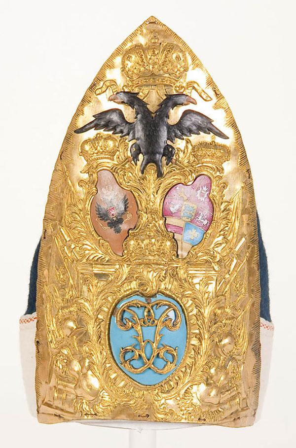 IMPERIAL RUSSIAN HELMET: AN IMPERIAL RUSSIAN GRENADIER MITER CAP PLATE OF THE HOLSTEIN DRAGOON REGIMENT, PERIOD OF PETER III. The gilt brass plate embossed with military trophies. The lower central section with period light b