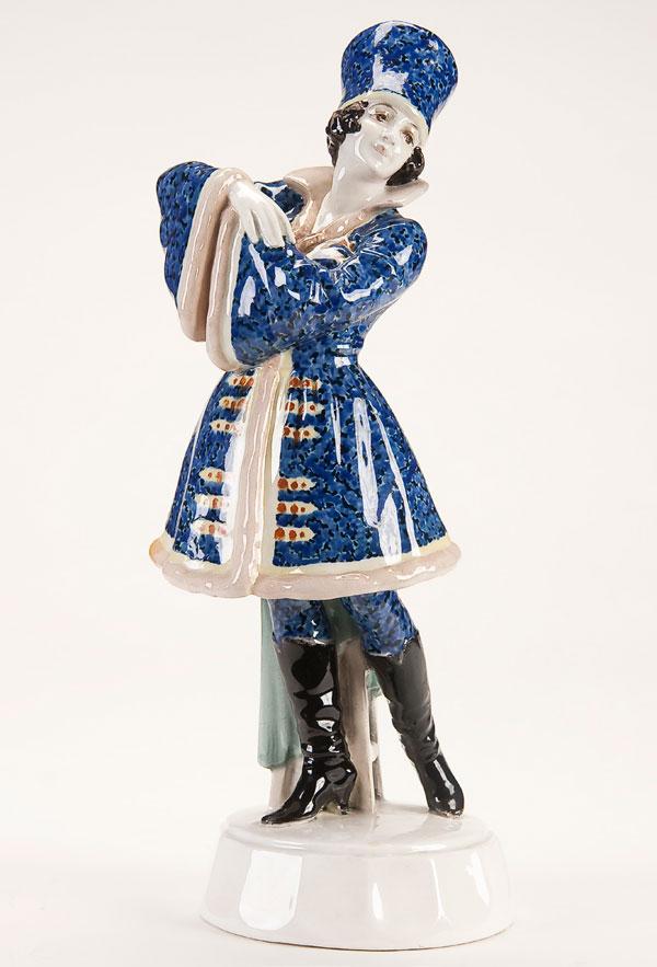 GOLDSCHEIDER FIGURE OF A FEMALE RUSSIAN COSSACK: A JOSEF LERNEZL FOR GOLDSCHEIDER FIGURE OF A RUSSIAN COSSACK FEMALE DANCER, CIRCA 1925. The finely modeled figure wearing black knee boots and blue Cossack-style attire. Base incised Lorenzl, undersid