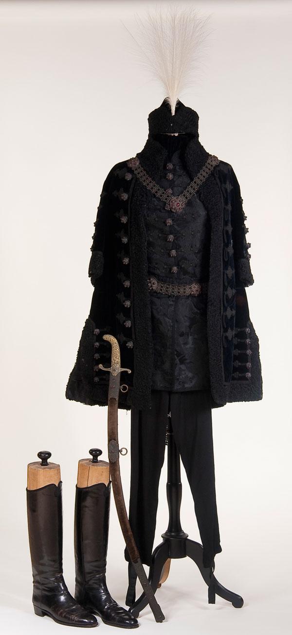HUNGARIAN NOBLEMAN DRESS SUIT & SWORD: AN IMPRESSIVE HUNGARIAN NOBLEMAN'S GALA DRESS SUIT WITH SWORD, CIRCA 1890. Comprising a cloak, tunic, cap, breeches, boots, sword and belt. Cloak of black velvet with matching fur trim and froggin