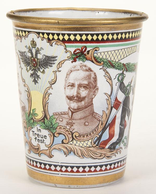 AUSTRIAN GERMAN WWI ENAMELED CUP: AN AUSTRIAN GERMAN WWI ENAMELED CUP, 1915. The side colorfully enameled with portraits of Emperor Franz Joseph and Kaiser Wilhelm between an Imperial Eagle and inscribed "In Faithfulness". Also with a