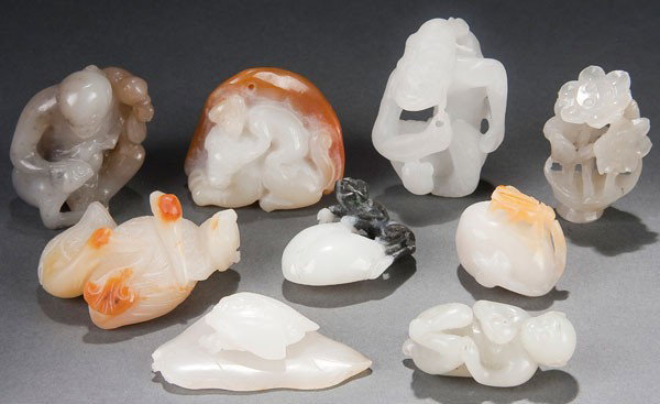 9 ORIENTAL JADE FIGURES/ORNAMENTS: NINE CHINESE CARVED JADE FIGURES/ORNAMENTS 19th/20th century. Of various forms in white jade including Lohan, monkeys, cicada, fruit and lotus. Several with russet skin. Height 1.25 inches to 2 inches