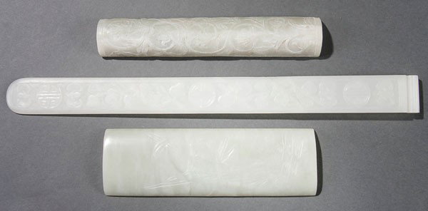 ORIENTAL JADE ORNAMENTS: A CHINESE CARVED WHITE JADE ORNAMENTAL GROUP 19th/20th century. Consisting of a very fine and well carved white translucent jade hair pin with relief of bats, fruit and Buddhist symbols. Together with