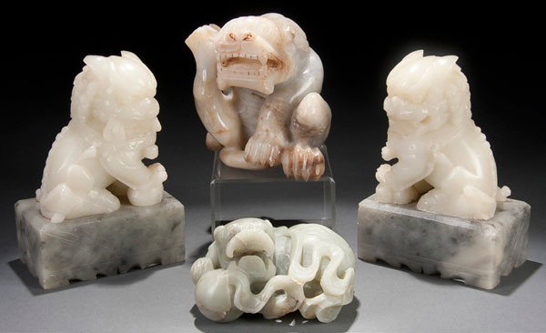 2 ORIENTAL JADE FIGURES: TWO CHINESE CARVED JADE BUDDHIST LIONS early 20th century. In celadon and white/gray colored jade. Largest 4 inches (10 cm). Together with a pair of bowenite carved Foo Dog bookends.