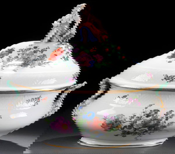 MEISSEN PORCELAIN TUREEN: A MEISSEN PORCELAIN TUREEN AND COVER 20th century. With hand painted florals and domed cover surmounted with a figure of a putto. Crossed swords mark. Length 13.75 inches (35 cm).