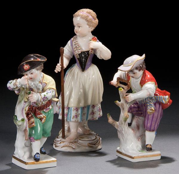 3 MEISSEN PORCELAIN FIGURES: THREE MEISSEN PORCELAIN FIGURES circa 1900 of boy gardeners depicted pruning trees and a young girl with a staff. Blue crossed sword marks. Height 4 inches and 5.25 inches (10 and 13 cm).