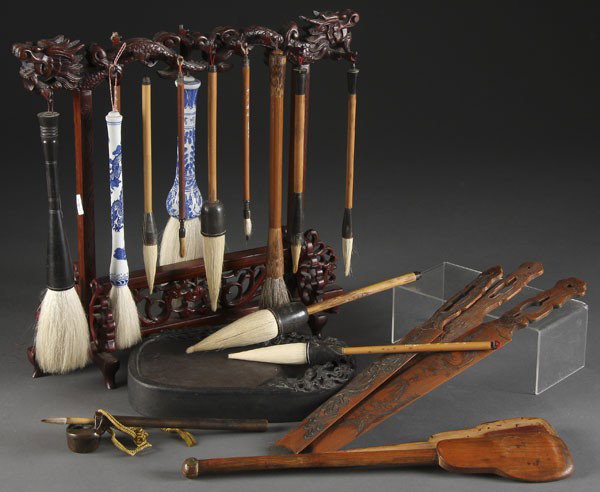 CHINESE BRUSH STAND & INKSTONE GROUP: A CHINESE BRUSH STAND & INKSTONE GROUP 20th century, consisting of a carved wood dragon form stand with 13 assorted brushes, a carved inkstone with dragon motif, a bronze inkwell pen and pen holder, a